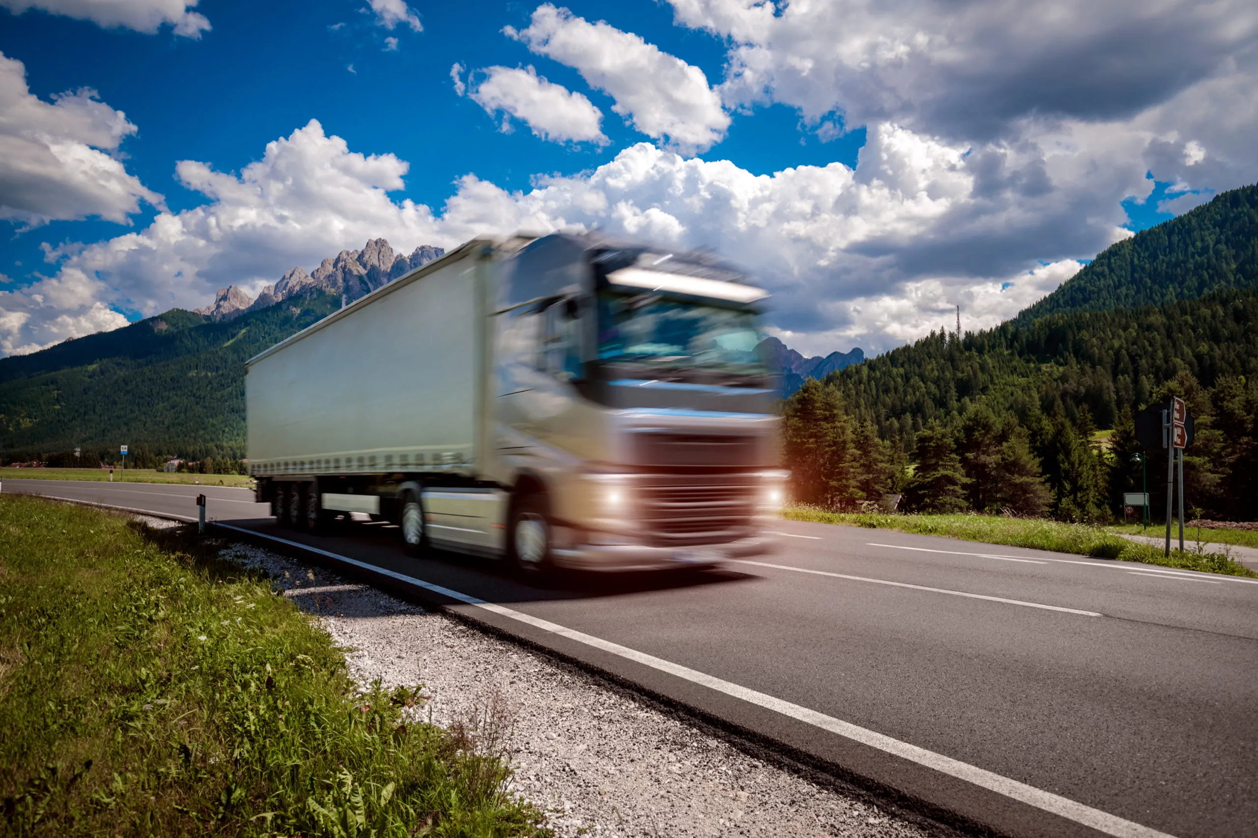 Fuel truck rushes down the highway in the background the Alps. Truck Car in motion blur.